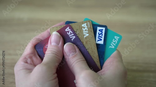 Vienna, Austria - 04 04 2026: Consumer Holding Stack of Plastic Cards at Table
