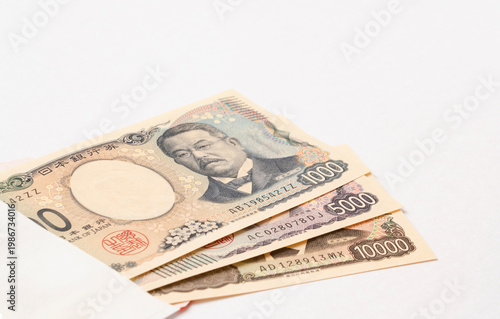 Japanese banknotes and a white envelope. Japanese currency, household finances, financial planning, savings, yen, money, finance, etc.　日本紙幣と白い封筒。日本紙幣、家計、財テク、貯蓄、貯金、円、お金、金融など