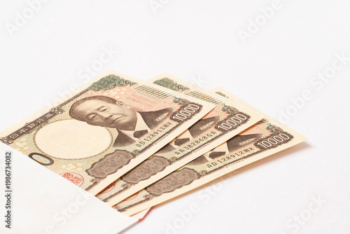 Japanese banknotes and a white envelope. Japanese currency, household finances, financial planning, savings, yen, money, finance, etc.　日本紙幣と白い封筒。日本紙幣、家計、財テク、貯蓄、貯金、円、お金、金融など