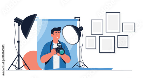Male photographer holding a camera in a professional studio setting with blue backdrop and professional lights and empty picture frames.