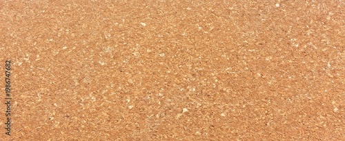 Close-up image of corkboard texture showing natural, rough surface with various shades of brown and irregular patterns.