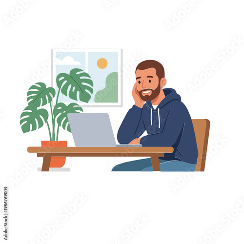 A man sits at a desk working on his laptop with a plant nearby indoors.