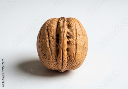 A single walnut on a white surface