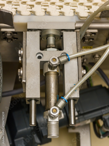 Detail of a linear pneumatic piston with a guide.