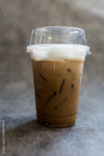 Iced Mocha coffee topped with milk foam in a glass. Close up