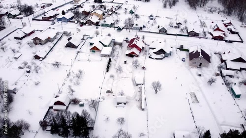 Cottage village in winter view from above snow drifts houses in the snow roofs in the snow top view with a drone. High quality 4k footage