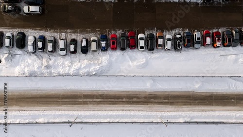 Winter snow road cars parked along the road top view from a drone. Winter snow parking. Colorful cars are parked along the road. High quality 4k footage