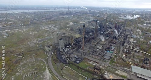 Aerial Riverfront Industrial Plant Emitting Smoke Near Waterway