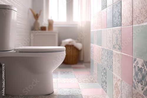A bathroom features a white toilet and colorful patterned tiles. Soft light fills the room, highlighting the tiles. A basket adds to the simple decor