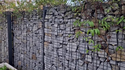 gabion wall,modern durable element of garden architecture.consists of wire baskets of galvanized steel cages, filled with natural stone. fencing of land, retaining for strengthening slopes. modern ben