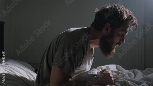 Adult man sitting in bed at night and yelling, visibly distressed and suffering from insomnia and mental health struggles