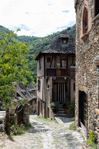 Historic cobblestone streets and medieval buildings in Conques village, Romanesque church, France