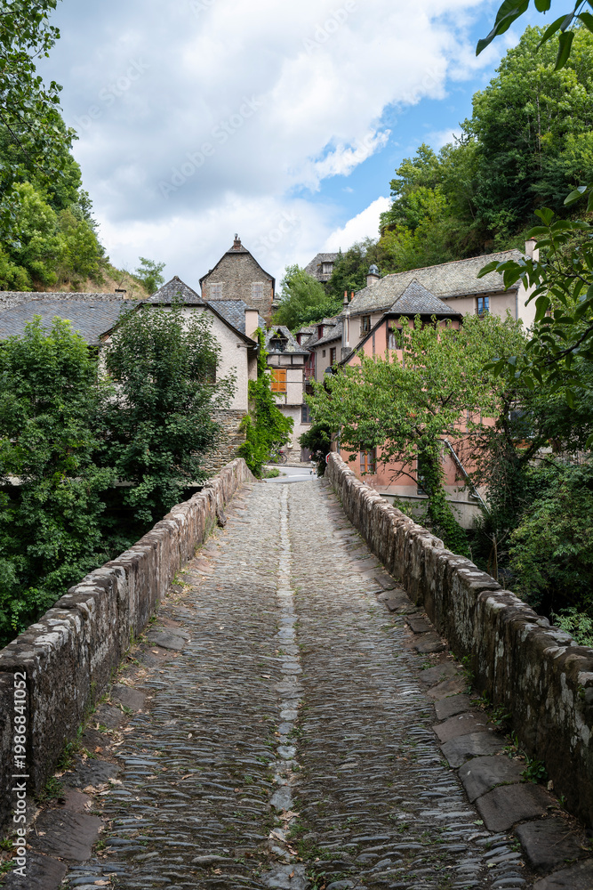 Fototapeta premium Ancient stone bridge at the entrance of the medieval village of Conques, Aveyron, France