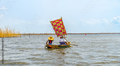 Fishermen in a small boat at lake Nokoué in Benin, West-Africa