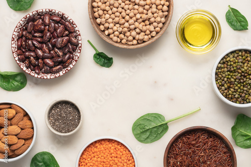 Bowls of beans and grains for healthy protein meal on light marble background with copy space