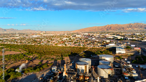 Aerial view of oil refinery with city and mountains in morning light