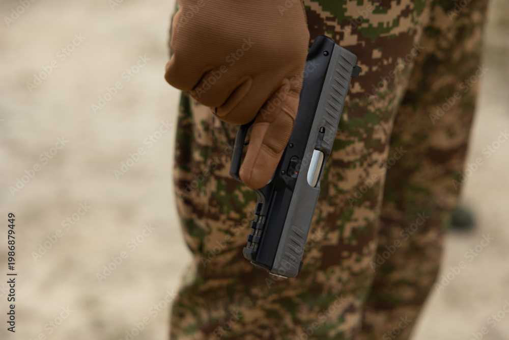 Obraz premium A boy in camouflage holds a gun