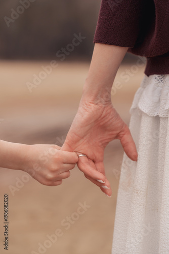 Konstfotografi Close up of a mother and child holding hands while walking, family connection, support and trust, outdoor lifestyle