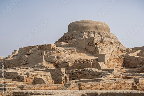 Closeup landscape view of citadel mound with buddhist stupa in archaeological ruins of UNESCO World Heritage Mohenjo Daro, Larkana, Sindh, Pakistan
