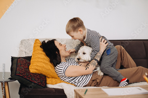 Mother and son playing with happy pet dog