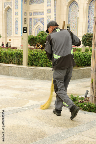 a janitor sweeps the street with a broom