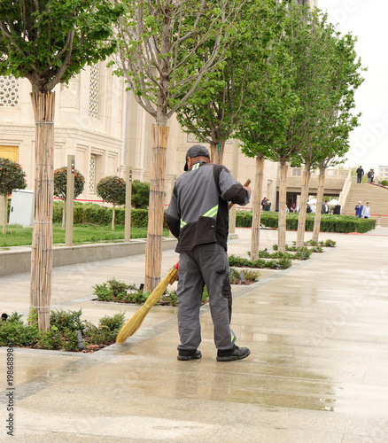 a janitor sweeps the street with a broom