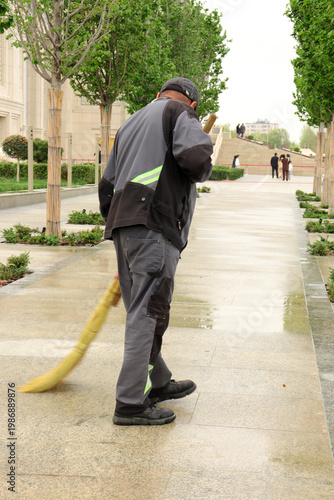 a janitor sweeps the street with a broom