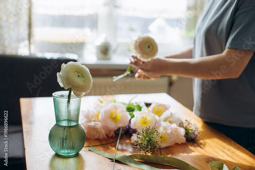 Foto Person arranging fresh ranunculus flowers for homemade bouquet