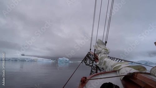 Cinematic POV shot from the bowsprit of the Schooner Amazone sailing through the Errera Channel toward Georges Point, Rongé Island, Antarctica