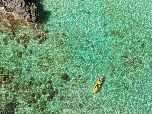 Obraz na plátně Aerial drone view of kayakers paddling through the crystal-clear turquoise waters of Big Lagoon in El Nido, Palawan, Philippines