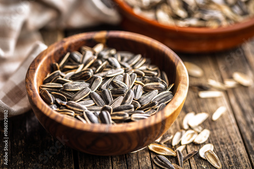 Sunflower Seeds in Bowl on Wooden Table With Scattered Shells Rustic Snack Background