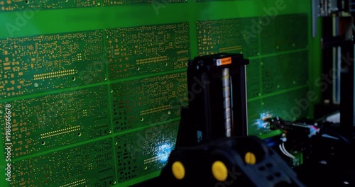 Modern industrial equipment. Industrial robot assembles an electronic board. Technological process of assembling a complex technical product .Close-up.