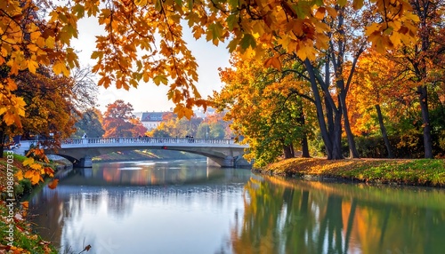 A serene river flows beneath a bridge, framed by vibrant, colorful fall foliage. The scene features trees and reflections