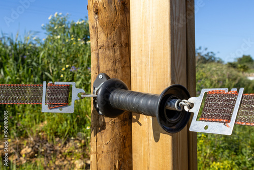Fényképezés Electric fence gate handle with spring and strap attached to wooden posts