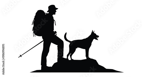 Silhouette of a hiker with a dog standing atop a rocky outcrop