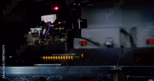 A close up view of automated machinery inserting components onto a circuit board during the manufacturing process. Robotic assembling microchip. Closeup shot.