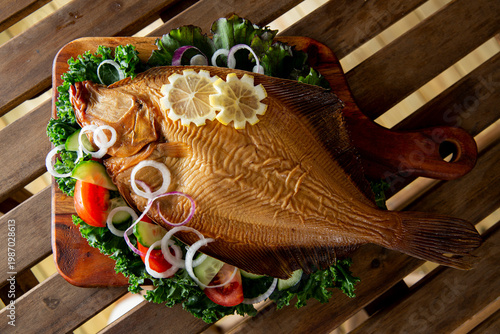 Tableau sur toile Smoked flounder fish (savukampela) served on rustic wooden board with kale, toma