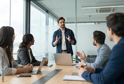 Young Creative Entrepreneur Leading Team Meeting and Brainstorming Session in Modern Bright Coworking Office.