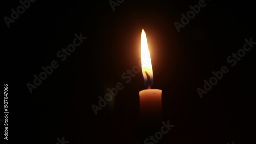 A macro shot of a flickering candle flame against a dark background, conveying a warm and cozy ambiance, loopable, looping