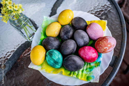 Wallpaper Mural Dyed easter egg on colored napkin in plate, small vase with primrose on table. Torontodigital.ca