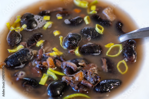 Wallpaper Mural Black bean soup with vegetable and sliced leek in white plate, spoon. Torontodigital.ca