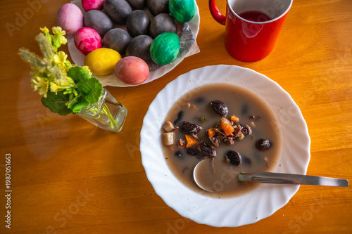 Wallpaper Mural Black bean soup, spoon, easter colored egg in bowl, flower and part of red cup on table. Torontodigital.ca