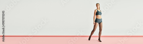 Valokuva A graceful young woman exudes poise and confidence while dancing in a minimalist