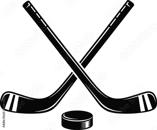 Two crossed ice hockey sticks with a puck black and white vector silhouette illustration isolated on white background for winter sports and competition design.
