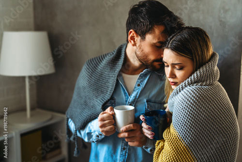 Slika na platnu A loving couple shares a quiet winter morning wrapped in warm blankets, finding
