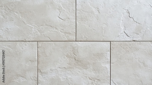 Close up view of textured light colored tiles with  stone like appearance laid in staggered brick pattern with dark grout lines