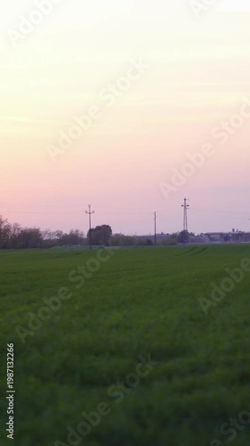 Car side window view of sunset over green farm field slow