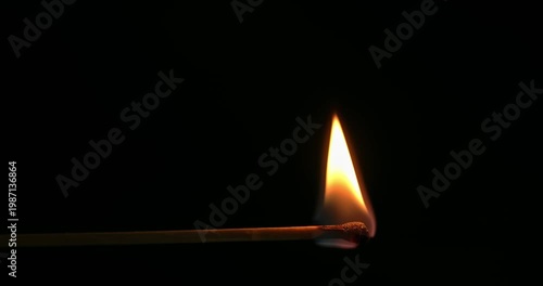Match is lit and burning on a black background.