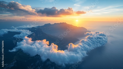 The mountain range, towering above the clouds at sunset, exudes grandeur and serves as a backdrop for nature or travel.