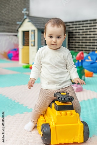 Toddler playing with ride-on toy car in daycare